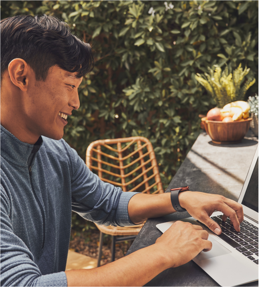 Guy sitting at table outside using a laptop