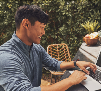 Guy sitting at table outside using a laptop